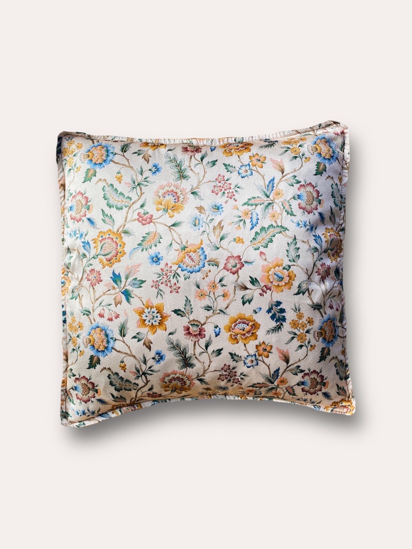 Close-up image of a Liberty Fabric Eva Belle Silk Cushion. The cushion features vibrant colors and intricate patterns, crafted from sumptuous silk fabric, adding elegance and sophistication to any home decor.