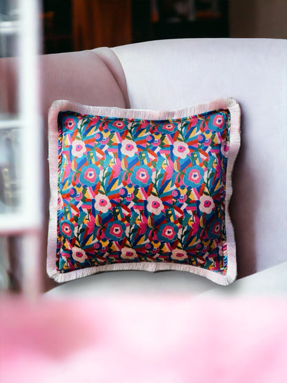 Close-up image of a Liberty Fabric Bloomsbury Silk Cushion with a powder pink fringe edge. The cushion features intricate patterns inspired by the Bloomsbury design on luxurious silk fabric, adding elegance and charm to any home decor.