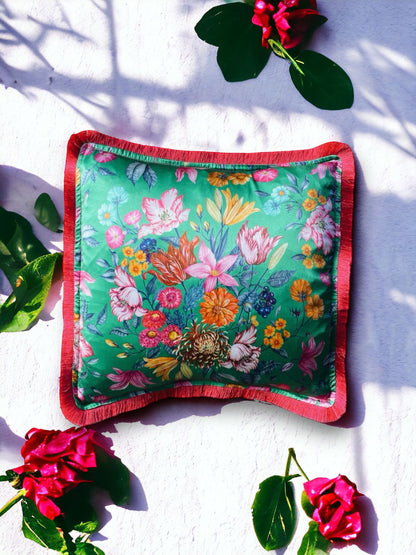 Close-up image of a Liberty Fabric Stately Bouquet Silk Cushion with a fuchsia pink fringe edge. The cushion features intricate floral patterns on luxurious silk fabric, adding vibrancy and elegance to any home decor.