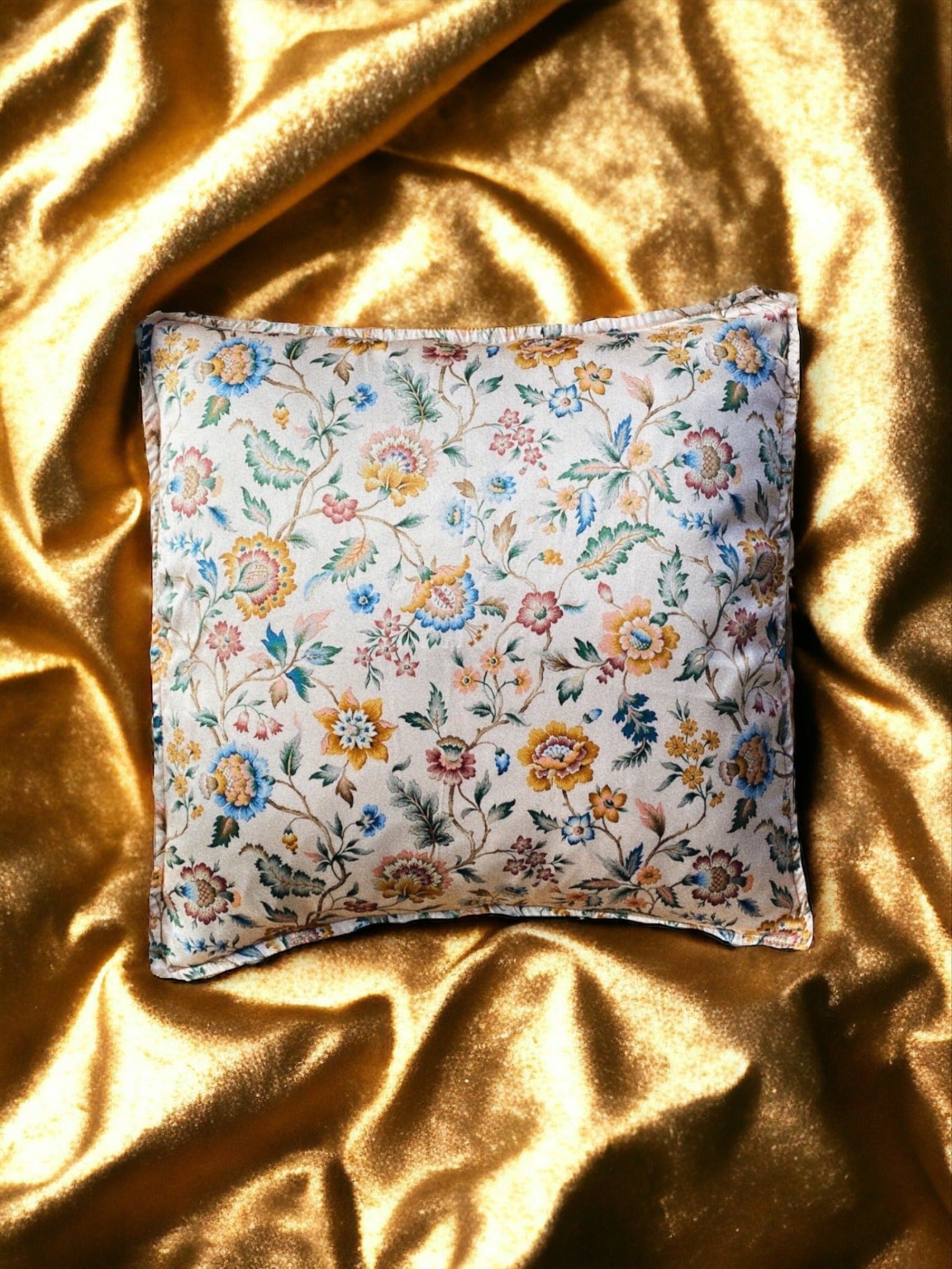 Close-up image of a Liberty Fabric Eva Belle Silk Cushion. The cushion features vibrant colors and intricate patterns, crafted from sumptuous silk fabric, adding elegance and sophistication to any home decor.