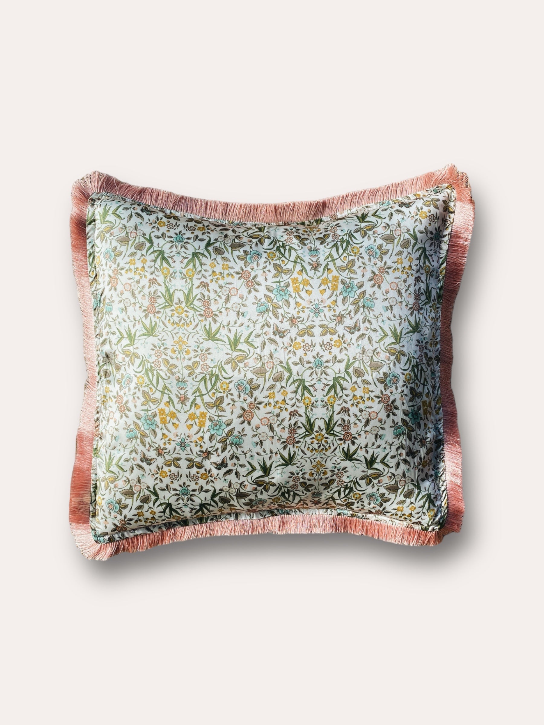 Close-up image of a Liberty Fabric Tapestry Silk Cushion with a delicate dusty pink fringe edge. The cushion features an intricate tapestry design crafted from sumptuous silk, adding sophistication and warmth to any home decor.